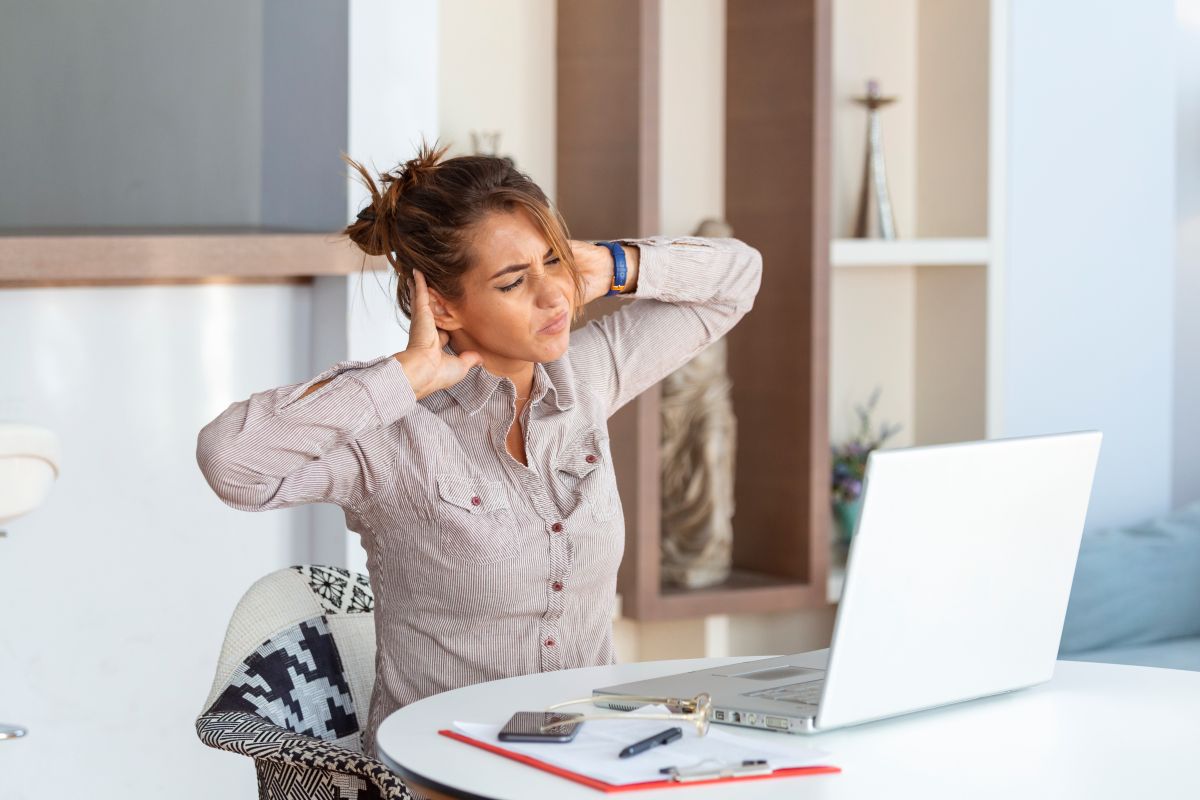 Person experiencing neck discomfort after working at a desk