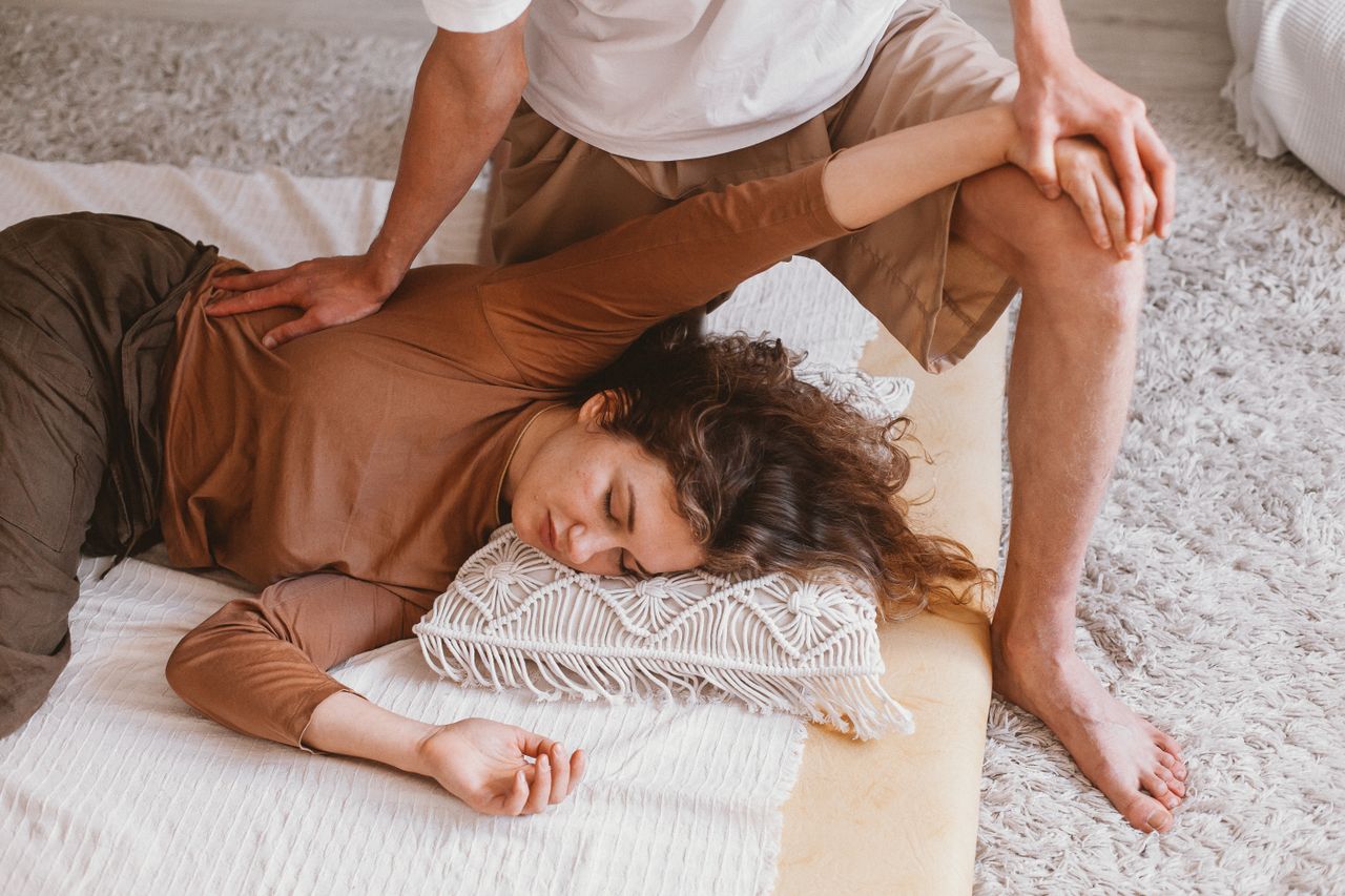 Assisted shoulder stretch during a sports massage session