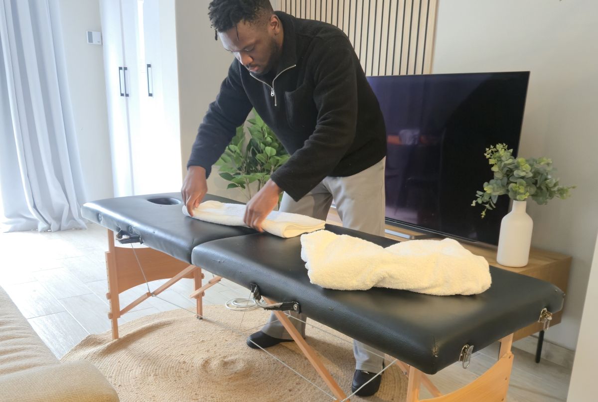 Mobile massage therapist preparing equipment for a home treatment